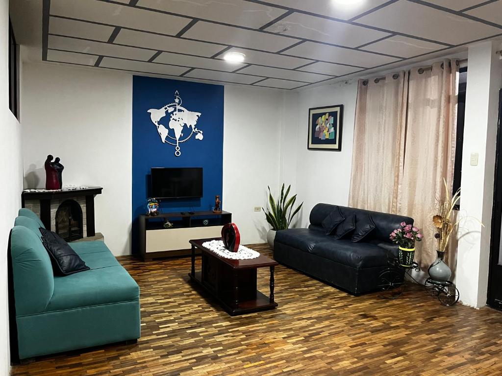 een woonkamer met een bank en een tv bij Amplio y cómodo departamento. in Loja