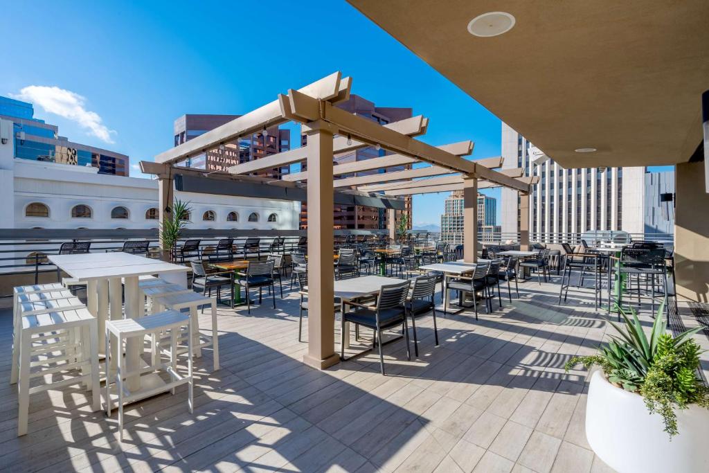 a patio with tables and chairs on a roof at Hilton Garden Inn Phoenix Downtown in Phoenix