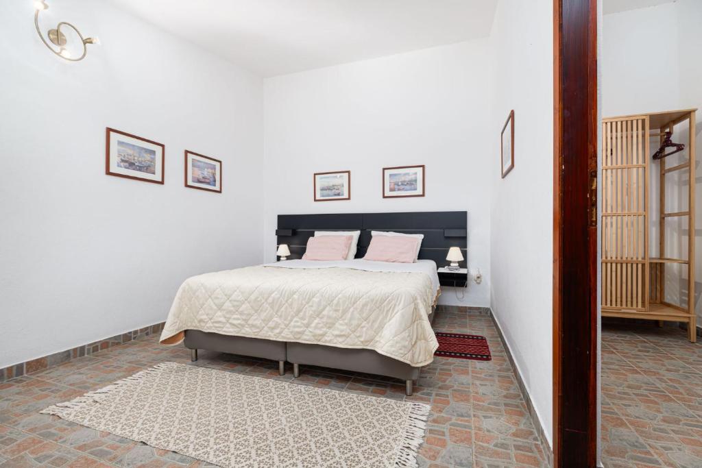 a bedroom with a large bed with pink pillows at St. Bečić in Poreč