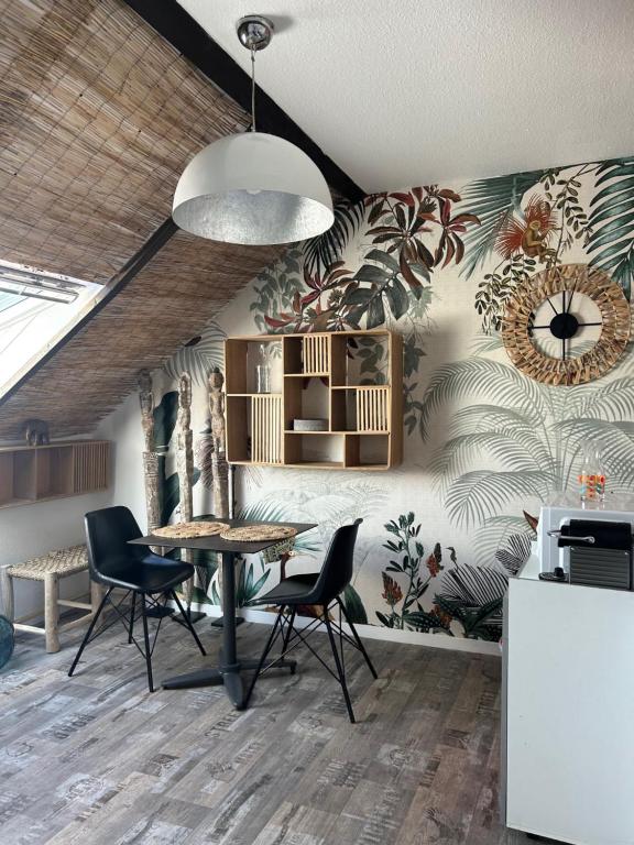 a kitchen with a table and chairs in a room at LE BALI in Besançon