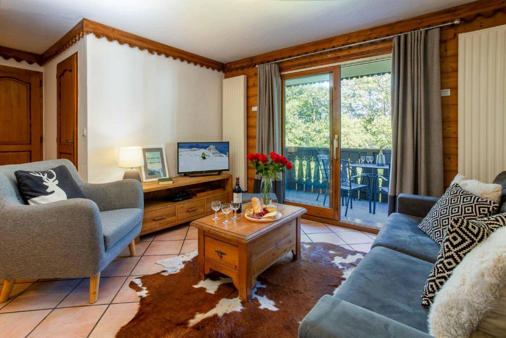 a living room with couches and a tv and a table at Ginabelle 14 apartment - Chamonix All Year in Chamonix-Mont-Blanc