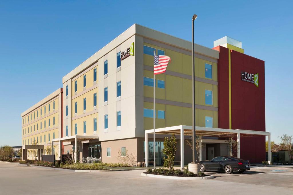ein Bürogebäude mit amerikanischer Flagge davor in der Unterkunft Home2 Suites by Hilton Houston Pasadena in Pasadena
