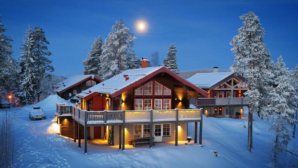 una casa en la nieve con la luna encima en Alpstigen 6B - 6 bäddars fjällstuga mitt i Järvsöbacken, en Järvsö