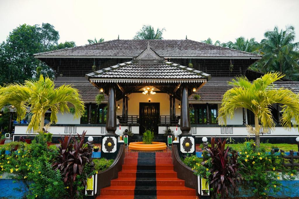 a home with a pathway leading to a gazebo at Arayathu Heritage Villa Resort in Kottayam