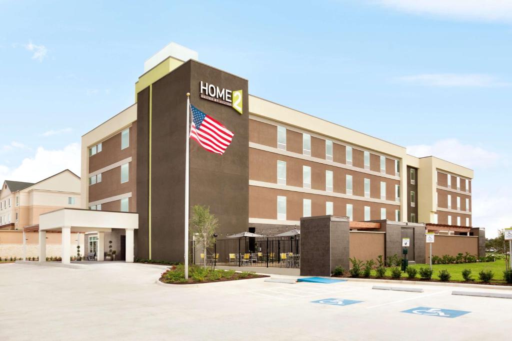 ein Hotel mit amerikanischer Flagge davor in der Unterkunft Home2 Suites by Hilton Houston Webster in Webster