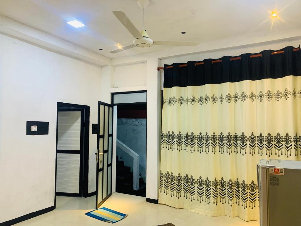 ein Zimmer mit einem Vorhang und einer offenen Tür in der Unterkunft Shehan Villa in Beruwala