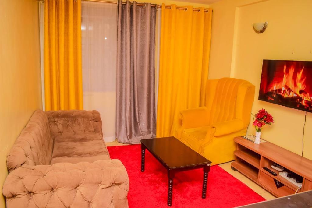 a living room with a couch and a chair at Belch 105 Apartment in Kisumu