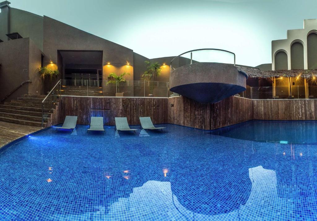 a large swimming pool with chairs in a building at Doubletree By Hilton Iquitos in Iquitos