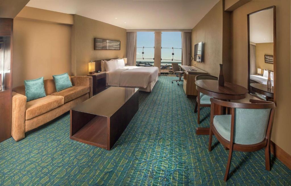 a hotel room with a bed and a couch at Doubletree By Hilton Iquitos in Iquitos
