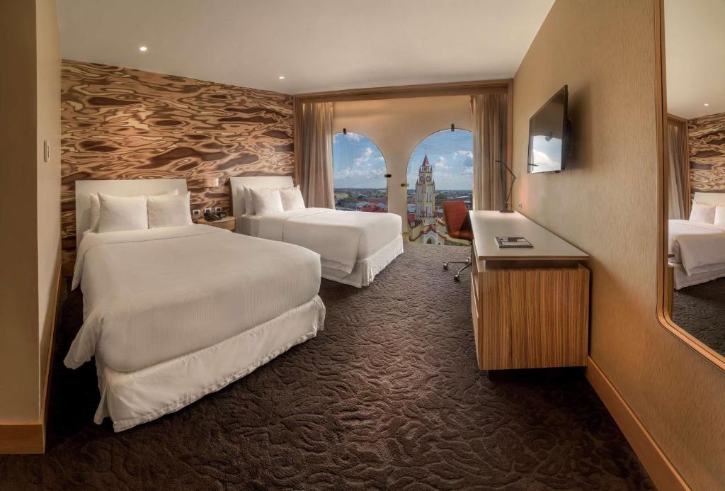 a hotel room with two beds and a sink at Doubletree By Hilton Iquitos in Iquitos