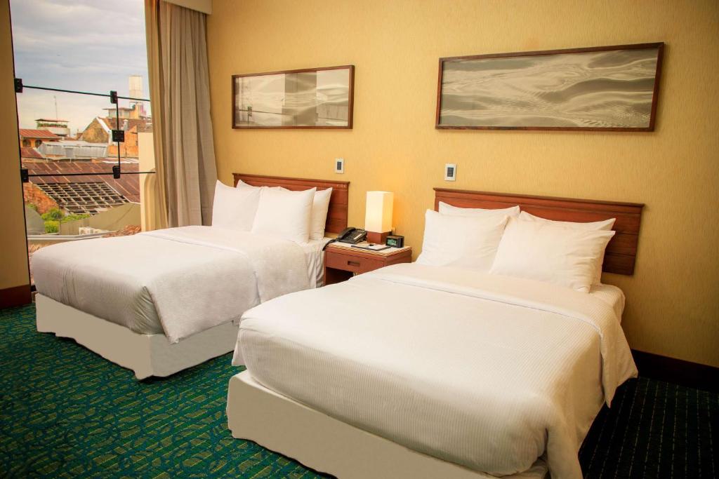 a hotel room with two beds and a window at Doubletree By Hilton Iquitos in Iquitos