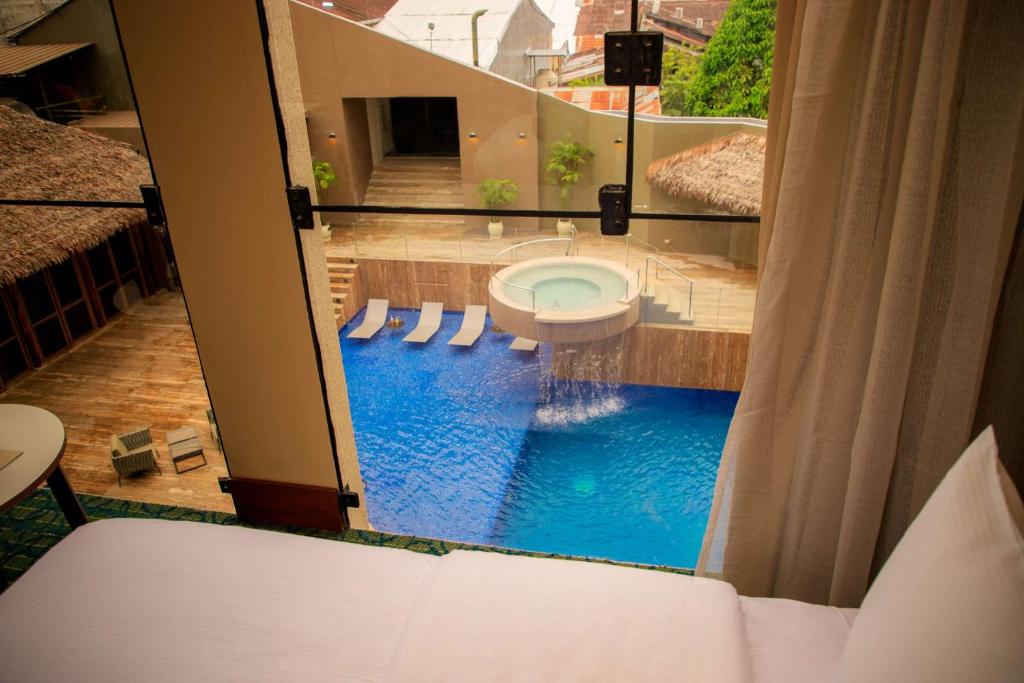 a bathroom with a toilet and a swimming pool at Doubletree By Hilton Iquitos in Iquitos