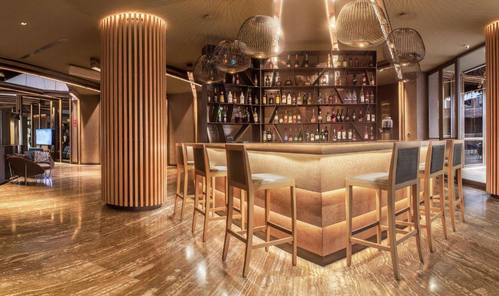 a restaurant with a bar with chairs and lights at Doubletree By Hilton Iquitos in Iquitos