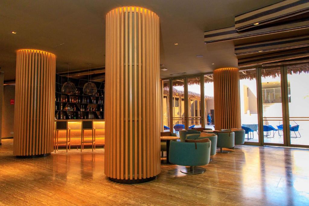 a lobby with columns with chairs and a bar at Doubletree By Hilton Iquitos in Iquitos