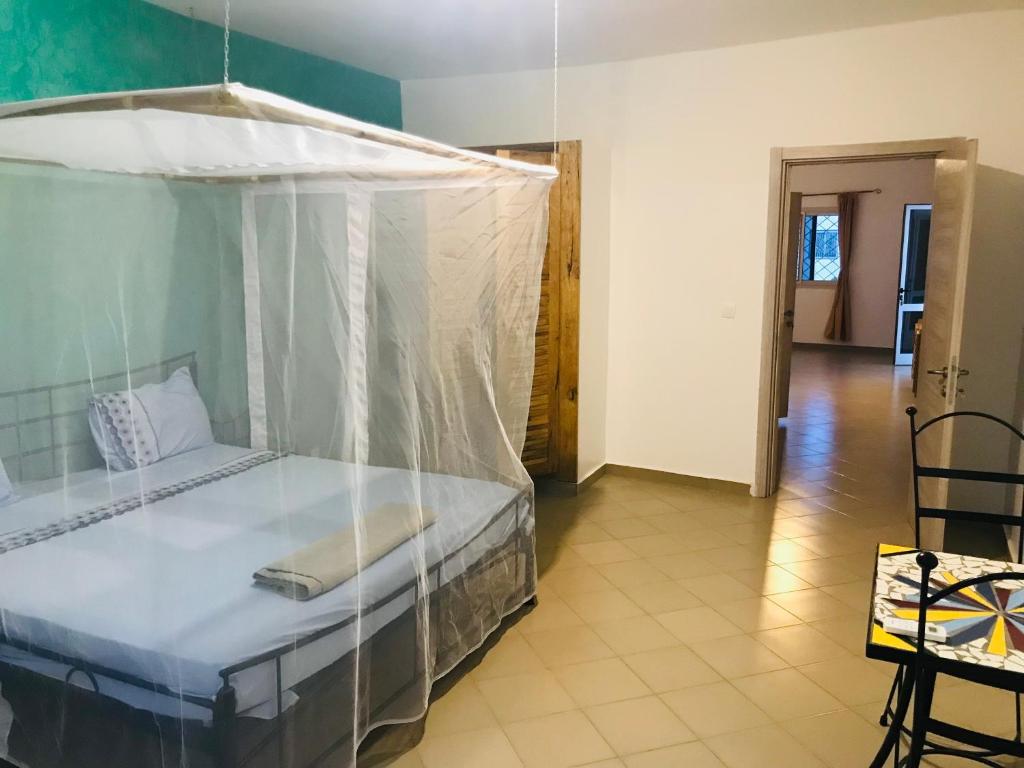 1 dormitorio con 1 cama con dosel en Villa Saraba, en Somone