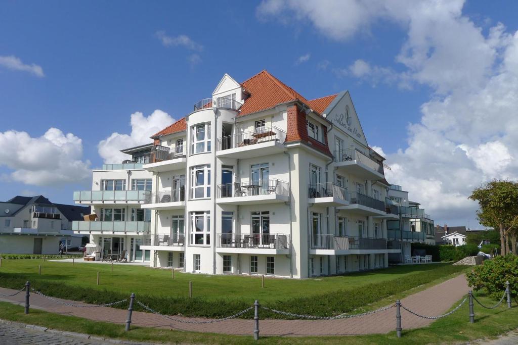 ein großes weißes Gebäude mit rotem Dach in der Unterkunft Schloss am Meer 17 in Wyk auf Föhr