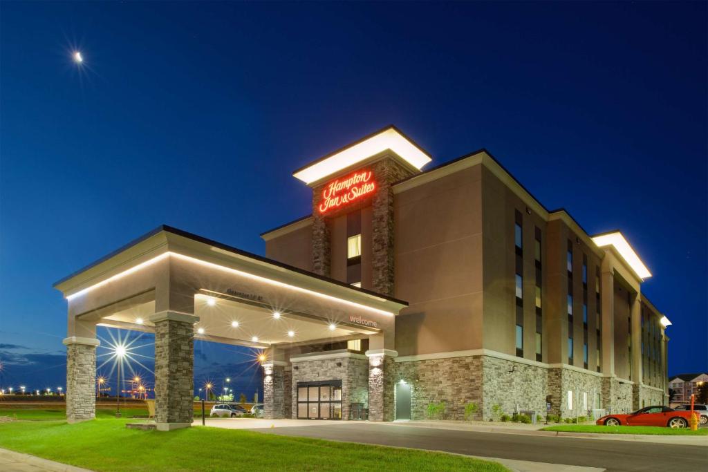 スーフォールズにあるHampton Inn & Suites By Hilton, Southwest Sioux Fallsの夜間の看板が貼られたホテルの建物