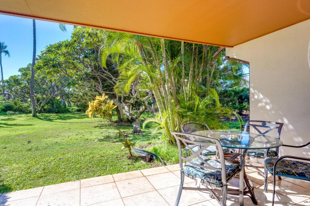 a table and chairs on a patio with a view of a yard at Koa Resort 1b in Kihei