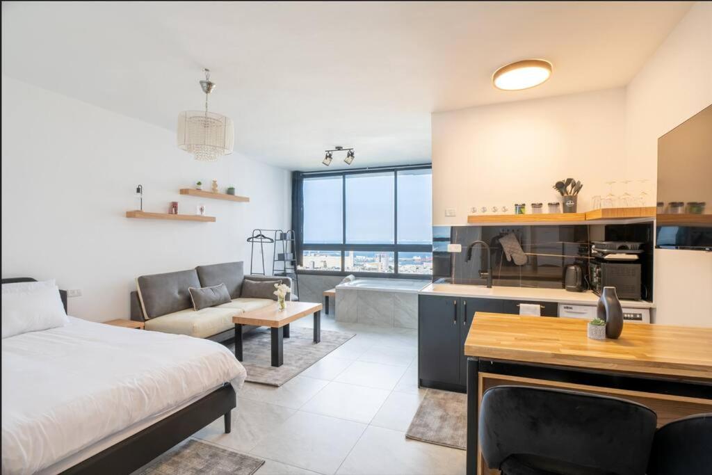 um quarto com uma cama e uma cozinha com uma banheira em eve's room em Haifa