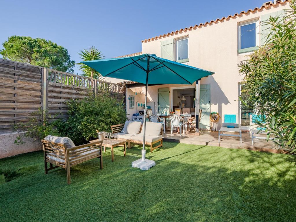 - une terrasse avec des chaises et un parasol dans la cour dans l'établissement Holiday Home Le Laurier by Interhome, à Le Plan