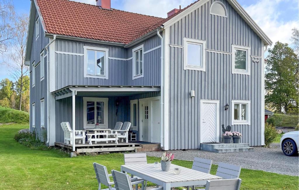 een grijs huis met een tafel en stoelen ervoor bij Gorgeous Apartment In Vrnamo With Kitchen in Förhult