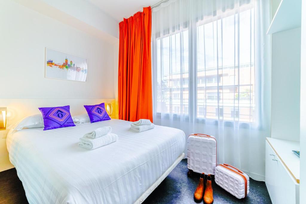 een slaapkamer met een bed en een groot raam bij Residence Montempo Lyon Cite Internationale in Lyon