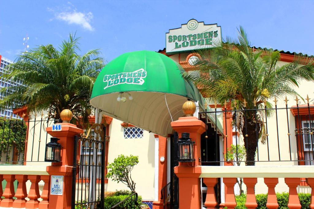 Sportsmens Lodge في سان خوسيه: مبنى فيه مظلة خضراء امام مبنى