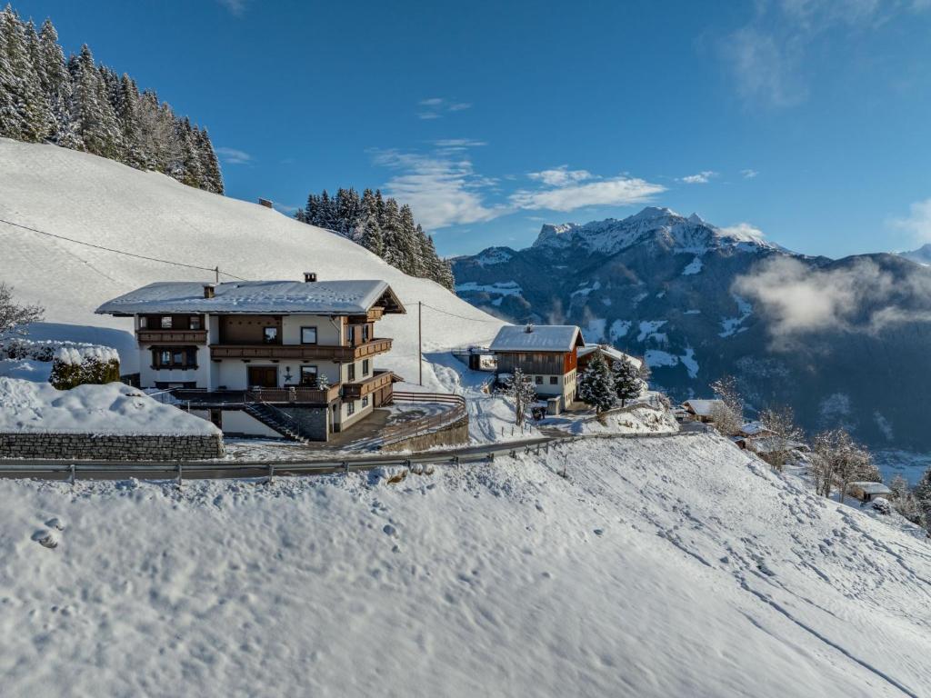 un edificio en la cima de una montaña cubierta de nieve en Apartment Haus Schöser by Interhome en Hippach