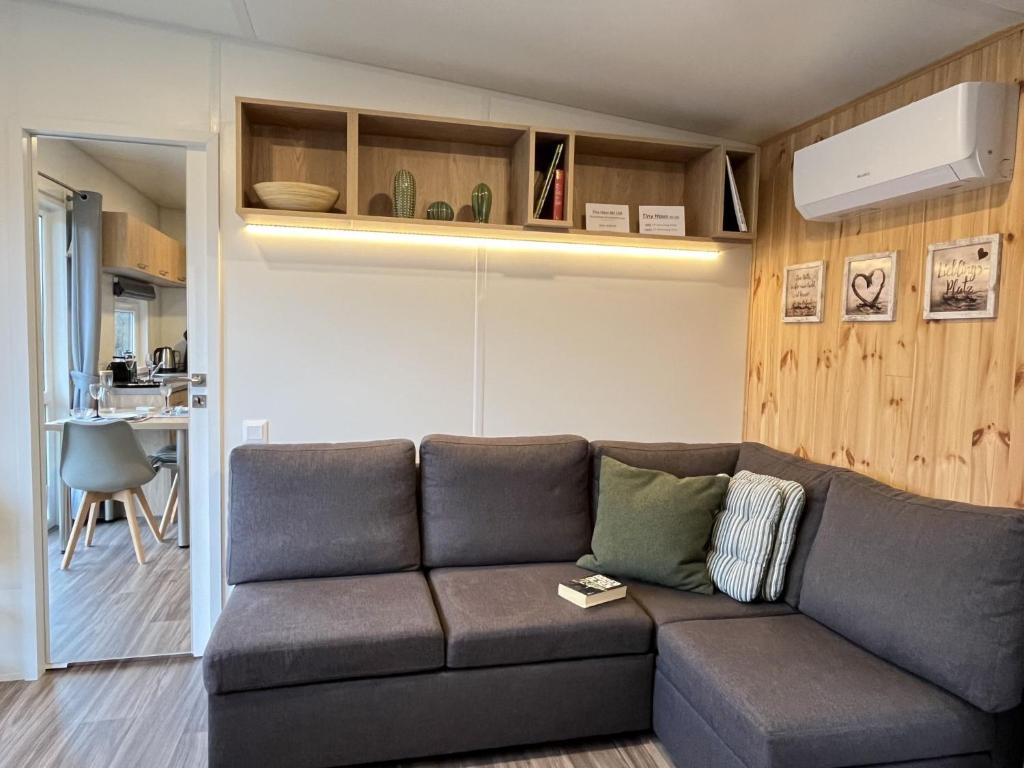 ein Wohnzimmer mit einem Sofa und einer Küche in der Unterkunft Holiday Home Tiny Haus mit schönem Seeblick by Interhome in Wemding