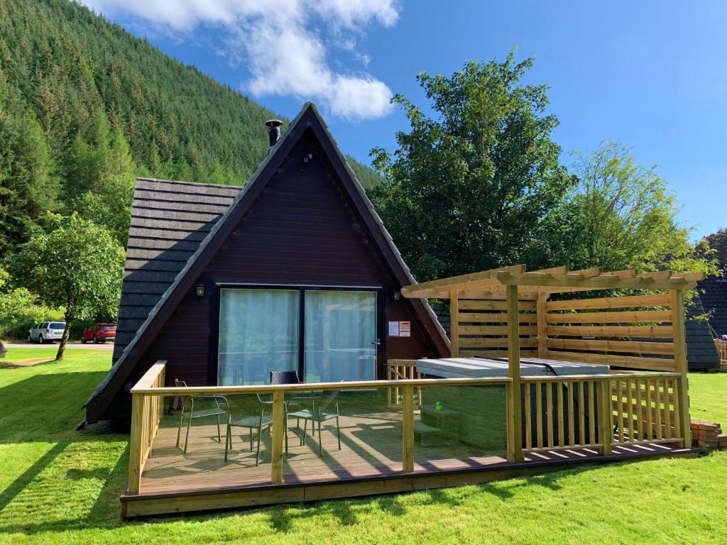 a cabin in the mountains with a deck at Chalet Lothlorien Lodge 4 by Interhome in Spean Bridge