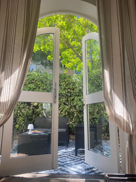 une porte ouverte menant à une terrasse avec une table. dans l'établissement Hôtel Ulysse Montpellier Centre, à Montpellier