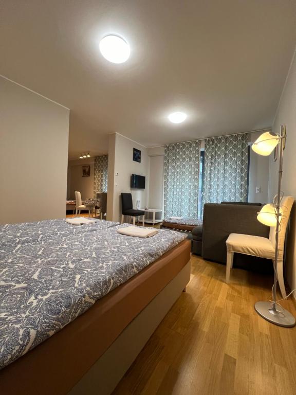 شقق إن ريزيدانس غاردين تاورز في براغ: غرفة نوم مع سرير وغرفة معيشة مع أريكة