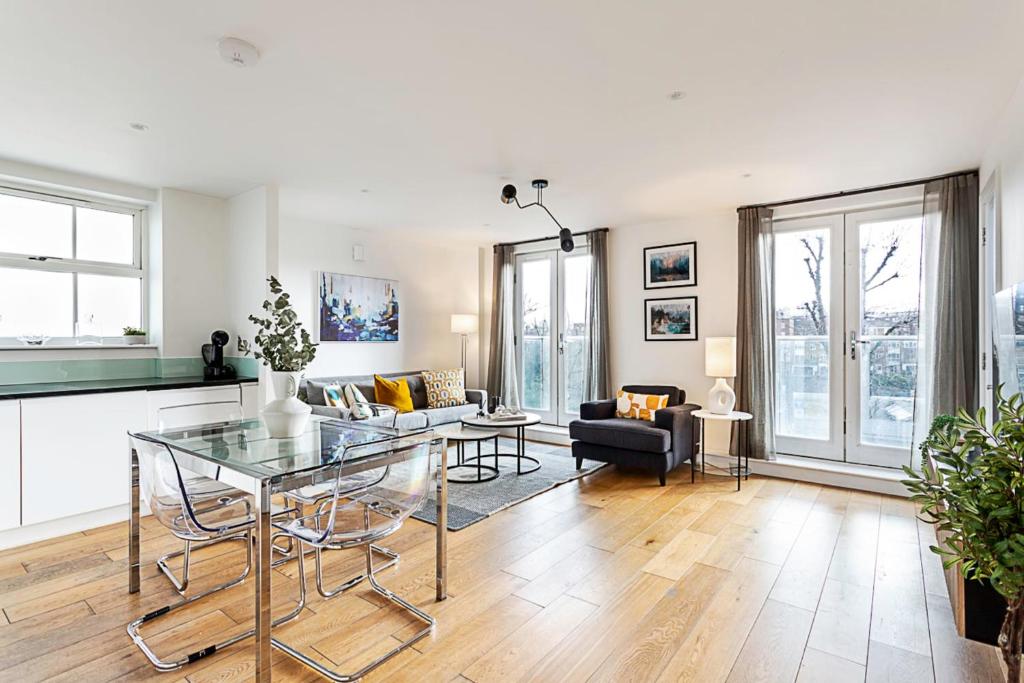 a living room with a glass table and a couch at Tranquil Belsize Park Haven with Stunning Views in London