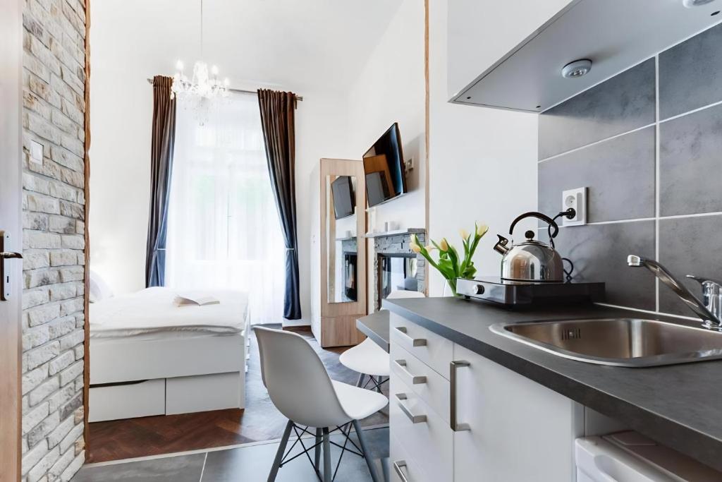 a kitchen with a sink and a counter with a chair at Dream Apartments Prague in Prague