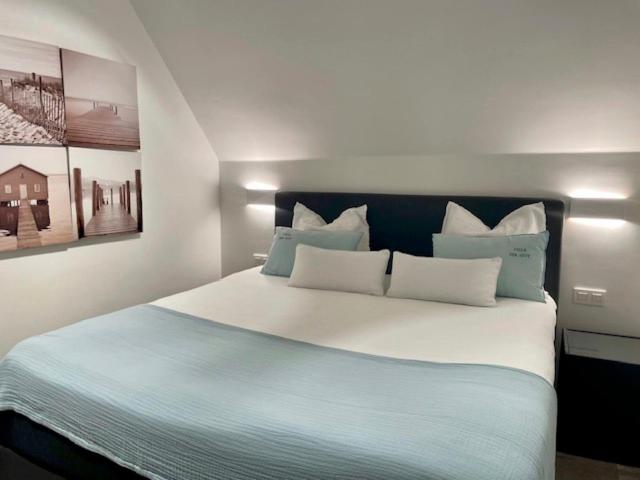 a bedroom with a large bed with blue and white pillows at VILLA FER-GUY " Beeldige Suite met parking, nabij strand en casino" in Knokke-Heist