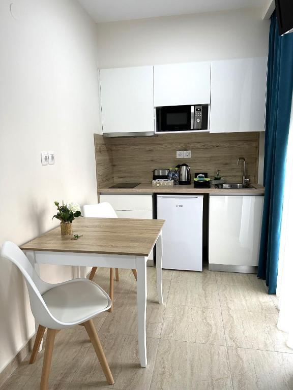 a small kitchen with a wooden table and a chair at Navarino Luxe Suites in Perea