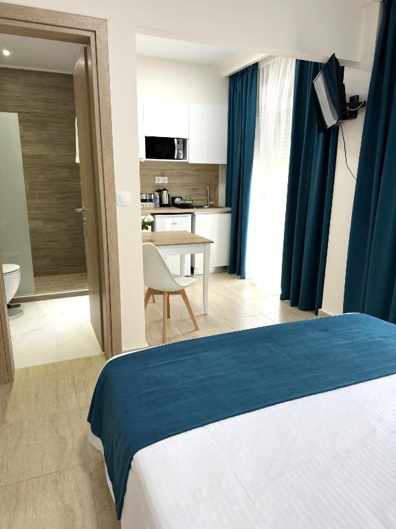 a hotel room with a bed and a kitchen at Navarino Luxe Suites in Perea