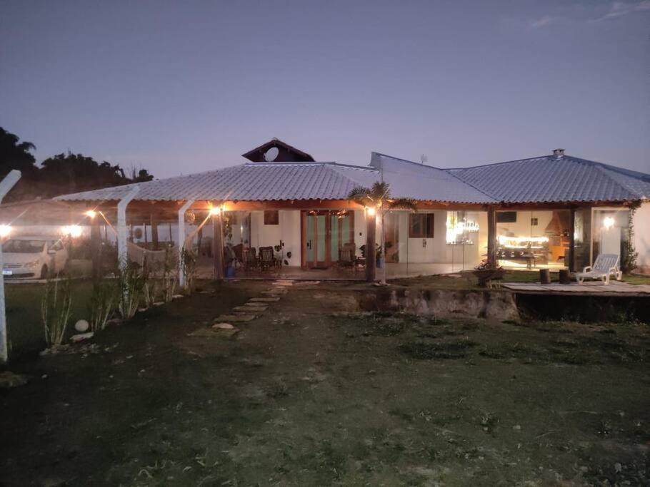 a house with lights in front of it at night at Chalé Canastra Zoo in Capitólio