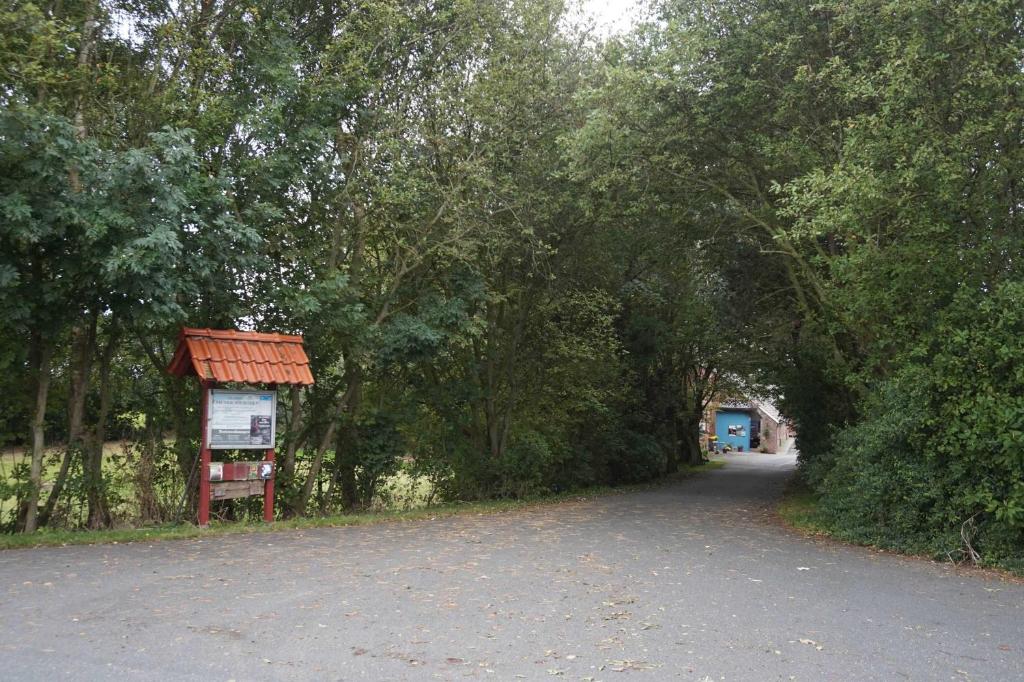 un camino con árboles y un letrero en el medio en Gulfhof Friedrichsgroden, en Carolinensiel