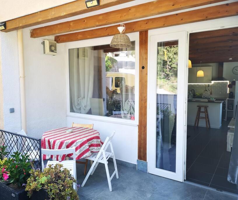 une table et des chaises sur une terrasse avec une fenêtre dans l'établissement beautiful apartment in Villa Sandrinella, à Gorbio