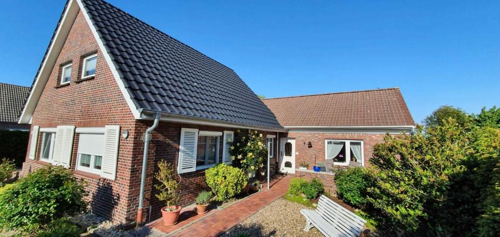 a brick house with a black roof at Ferienwohnung Johanne in Carolinensiel