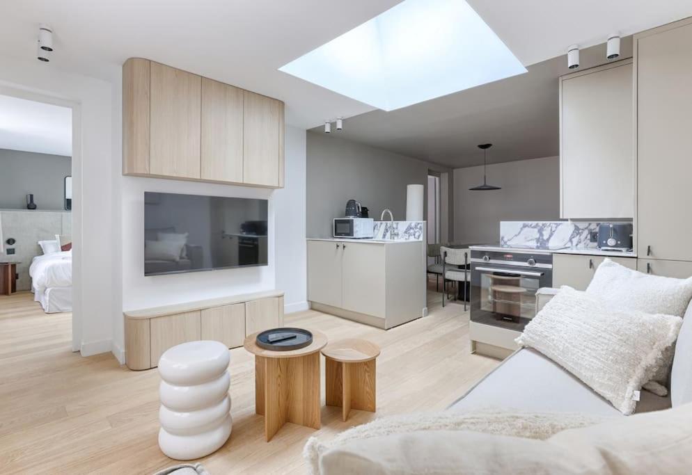 un salon avec un canapé et une cuisine dans l'établissement MyKeypers - Luxury Design Flat 2BR/6P - Rue de Charonne !, à Paris