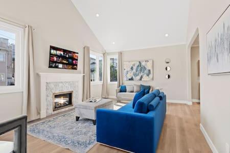 a living room with a blue couch and a fireplace at Champagne Taste Luxury Home in Hillcrest in San Diego