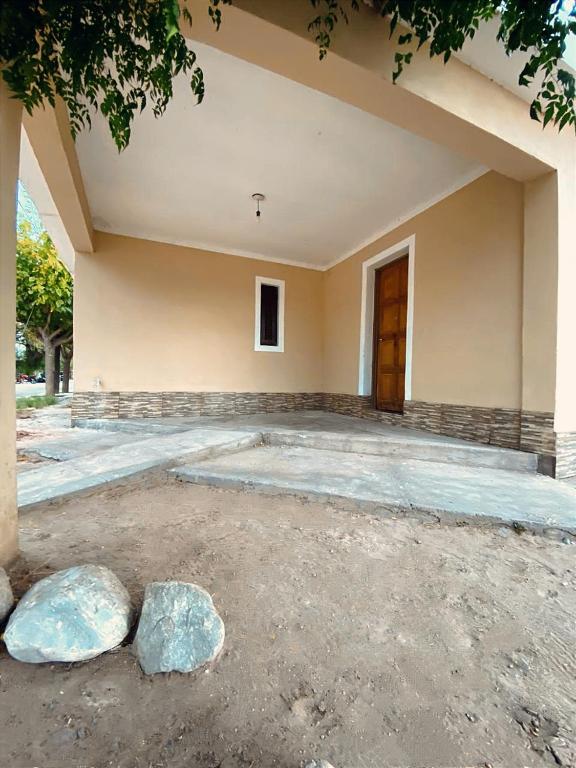 un bâtiment vide avec des rochers devant lui dans l'établissement Dunas Doradas, à Tinogasta