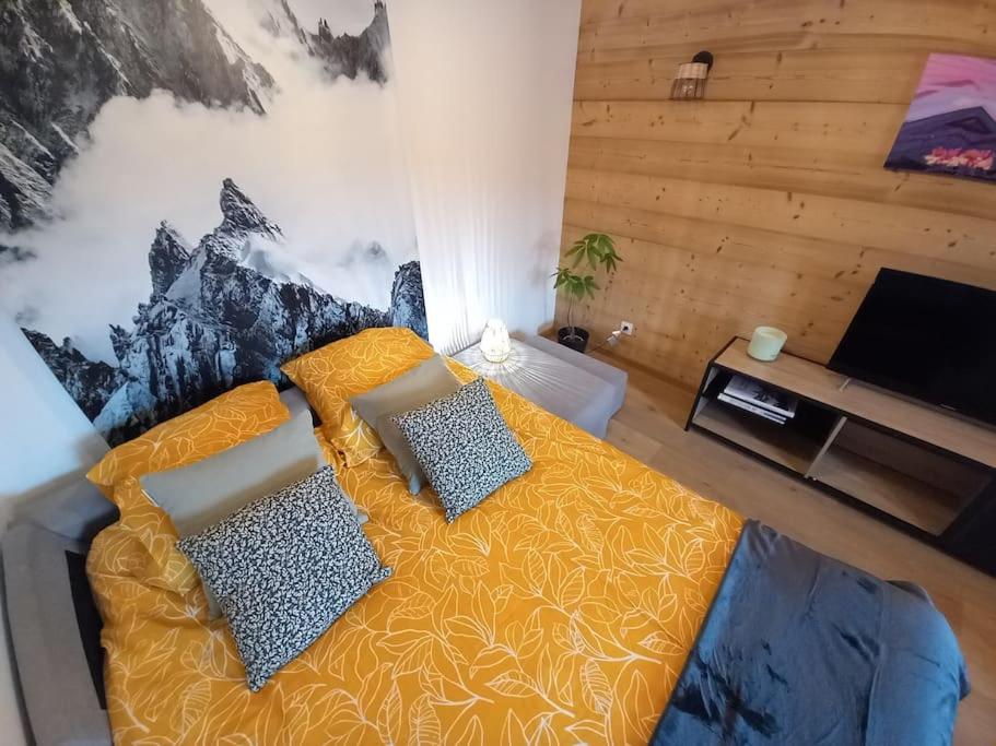 een slaapkamer met een bed met 2 kussens erop bij LE ZÈDÈL - Duplex 100m2 avec terrasse et jardin vue montagne in Aigueblanche