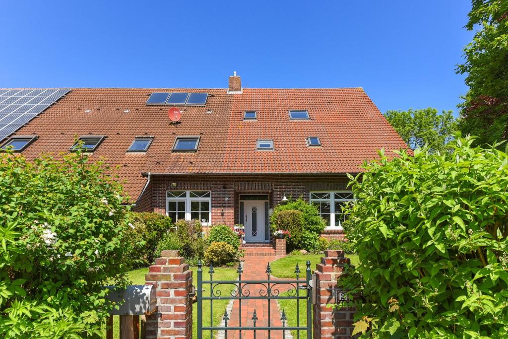 旺格兰Ferienwohnungen Janssen-Graalfs的红屋顶砖屋,有门
