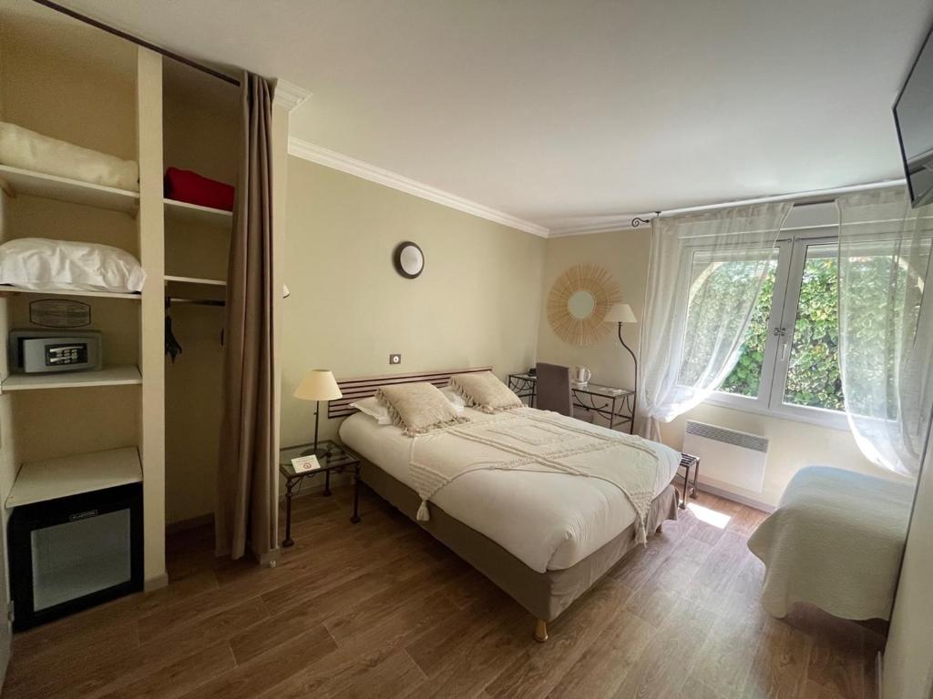 a bedroom with a bed and a large window at Hôtel Ulysse Montpellier Centre in Montpellier
