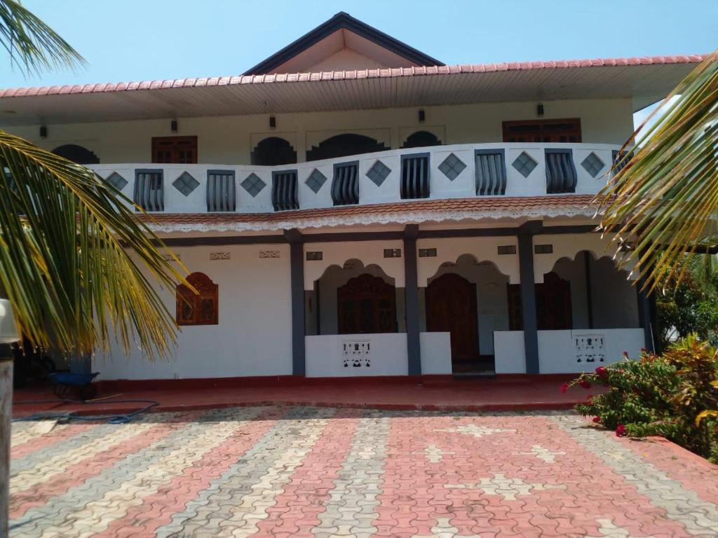 un edificio con una palmera delante de él en Nedunkerniy Sri Lanka, 
