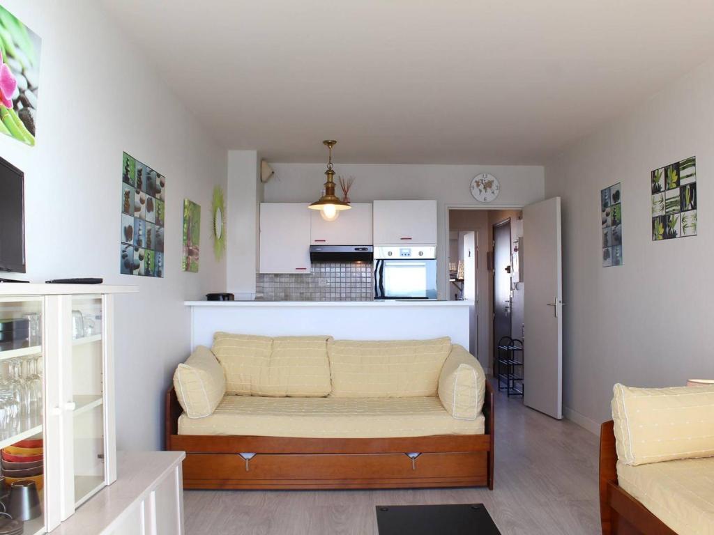 un salon avec un canapé et une cuisine dans l'établissement Appartement front de mer à La Baule : T2 avec terrasse, parking et Wifi - FR-1-245-120, à La Baule