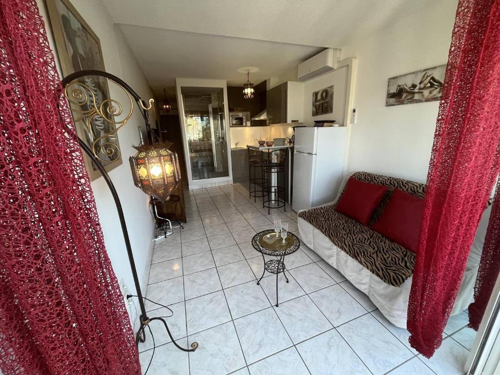 un salon avec un canapé et une cuisine dans l'établissement Studio cabine rénové climatisé, 2 couchages, plage à proximité - Cap d'Agde Naturisme - FR-1-249A-32, au Cap d'Agde